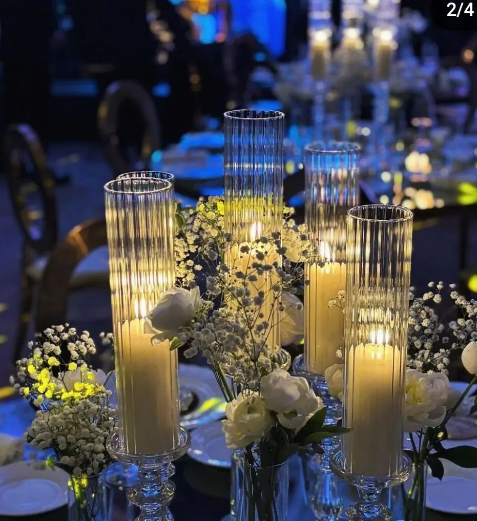 Dettaglio di un tavolo imperiale con candele accese e fiori bianchi.